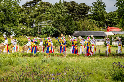 People standing on field by trees