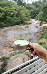 High angle view of hand holding drink against blurred background