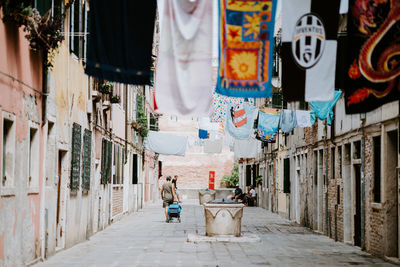 Rear view of woman walking on street amidst buildings