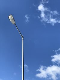 Low angle view of street light against blue sky