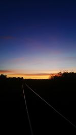 Silhouette railroad track against sky during sunset