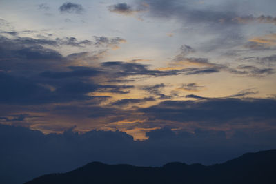 Low angle view of silhouette mountain against dramatic sky