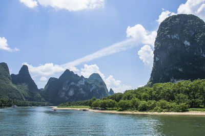 Scenic view of sea and mountains against sky