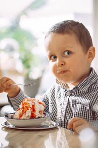 Portrait of boy eating food at home