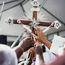 Low angle view of people hand holding cross