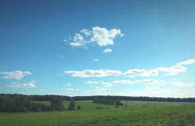 Scenic view of grassy field against cloudy sky