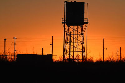 Silhouette water tower against clear sky during sunset