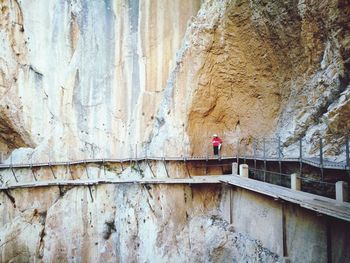 Woman on footbridge against mountain