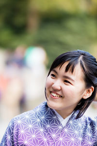 Close-up of smiling young woman standing outdoors