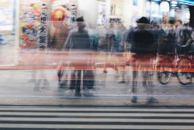 Blurred motion of man walking on street