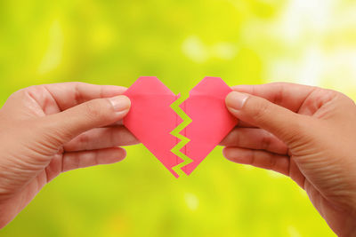 Close-up of hand holding broken heart shape