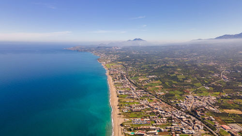 High angle view of townscape by sea against sky