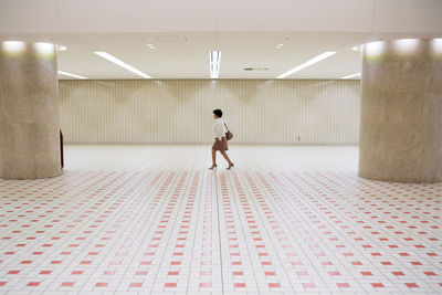 Full length rear view of woman walking in corridor