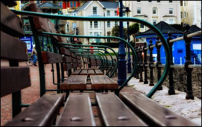 Empty benches in row against buildings