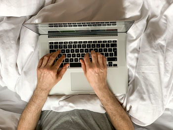 Middle aged man using laptop at home in bed vibes early morning working. freelancer, freelance job, 