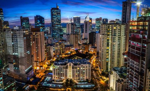 Aerial view of illuminated buildings in city against sky