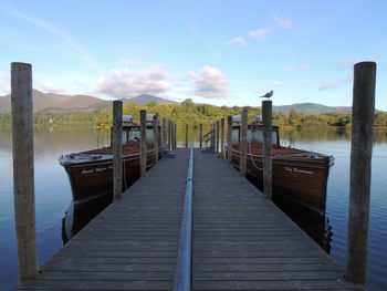 Wooden pier over lake against sky