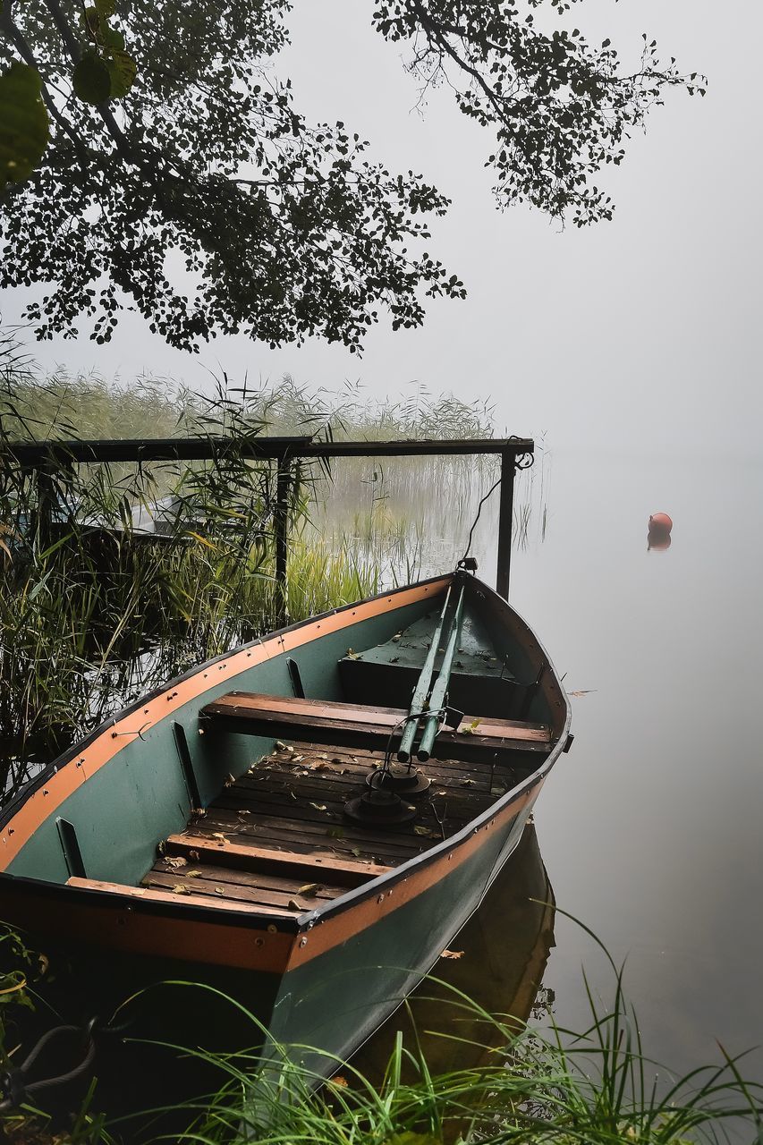 FISHING BOAT IN LAKE AGAINST SKY