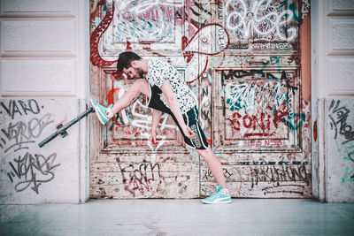 Woman with graffiti on wall