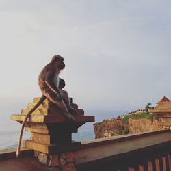 Statue by sea against sky