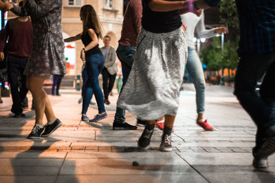 Low section of women walking on street in city