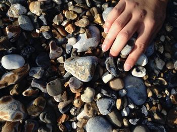 Cropped image of hand on pebbles