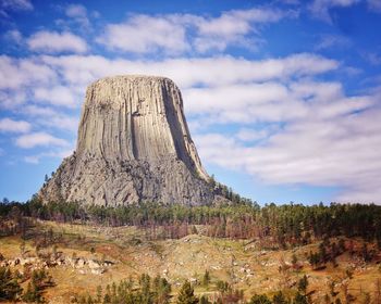 Low angle view of devils tower national monument against cloudy sky