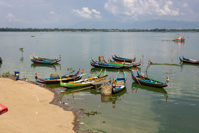 Boats moored in lake against sky