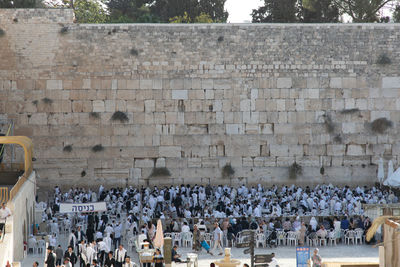 High angle view of people sitting against brick wall