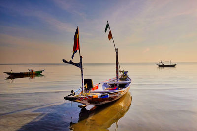 Nautical vessel on sea against sky during sunset