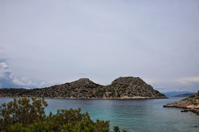 Scenic view of sea and mountains against sky