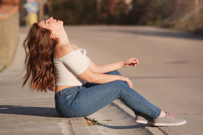 Side view of woman sitting outdoors