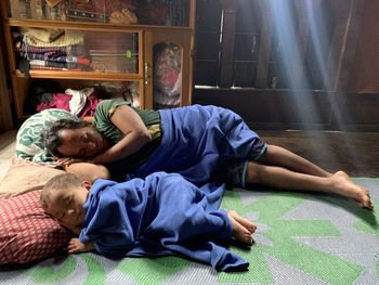 Rear view of mother and son on floor