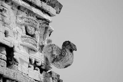 Low angle view of old sculpture against clear sky