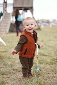 A portrait of a small boy playing and smiling outdoors at the pumpkin patch in colorado.