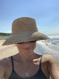 Portrait of woman at beach against sky