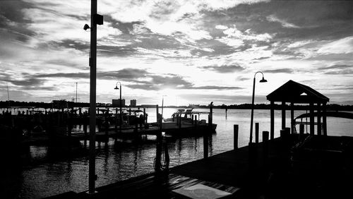 Boats moored at harbor against sky