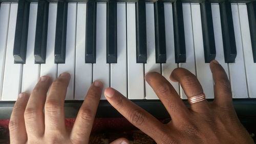 Close-up of hands playing the piano