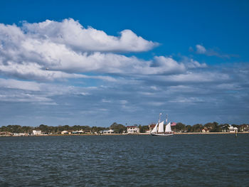 Sea by buildings against sky in city