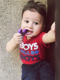 Portrait of cute baby boy against wall