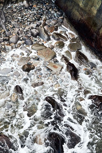 High angle view of stream flowing through rocks