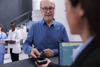 Portrait of man using laptop at clinic
