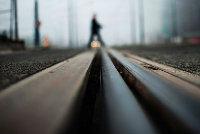 Surface level of railroad track with person walking in background