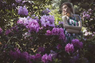 Lady embracing herself near flowering pink bushes scenic photography