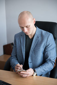 Businessman using mobile phone while sitting at table