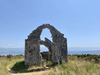 Old ruin on field against sky