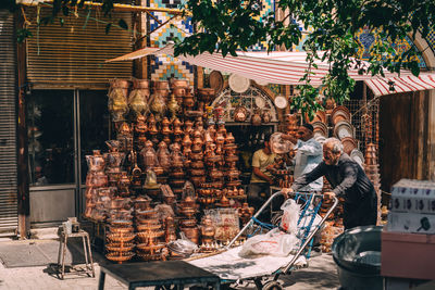 People working at market stall against building