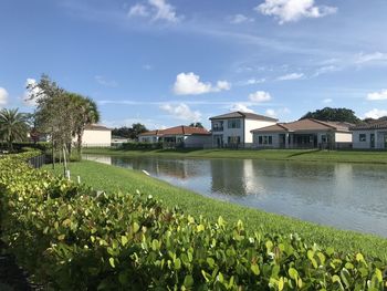 Scenic view of lake by buildings against sky