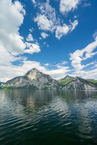 Scenic view of sea by mountains against sky