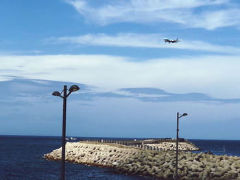 Seagull flying over sea against sky